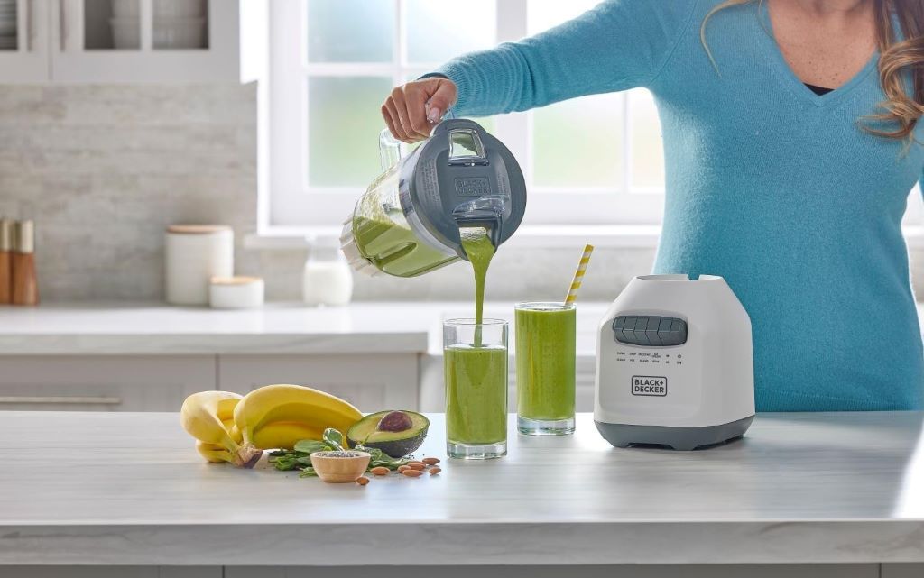 Blender in action crushing ice and fruits, showcasing BLACK+DECKER 750W power and durable design.