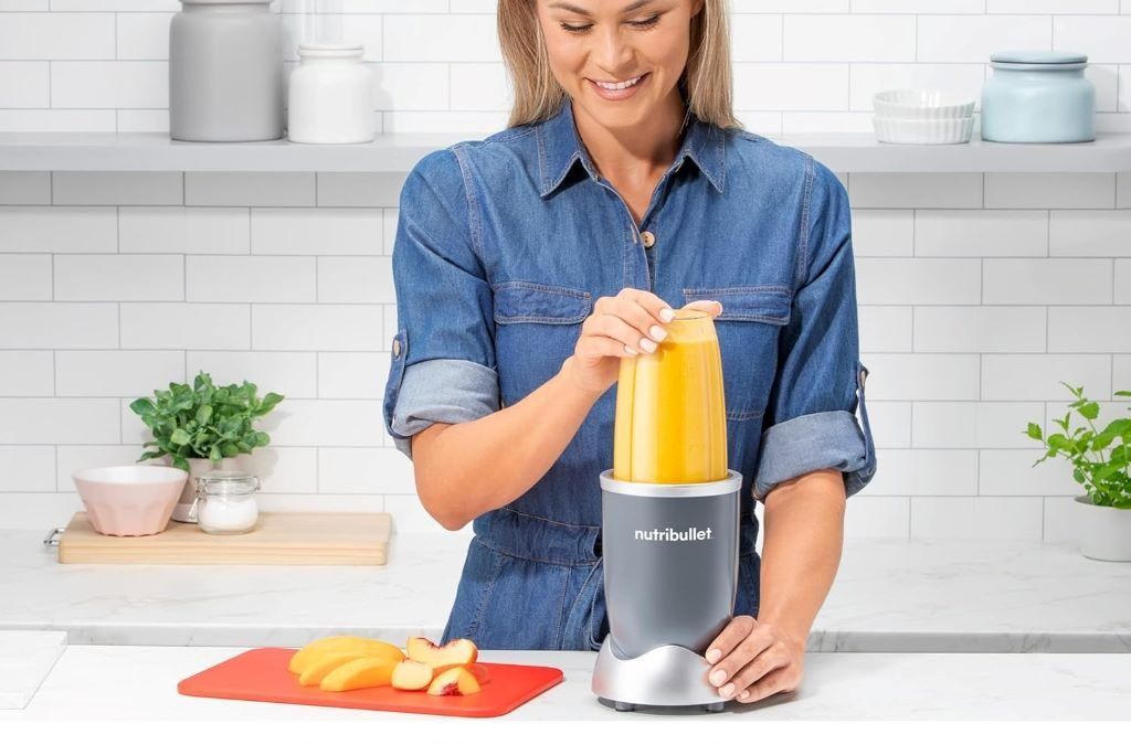 Close-up of Nutribullet 600W blender in use, blending fresh fruits into a smoothie in the 24oz cup