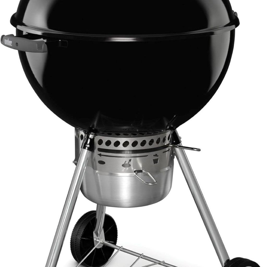 Weber 22″ kettle grill in action on a patio, with glowing charcoal and burgers sizzling on the grate.