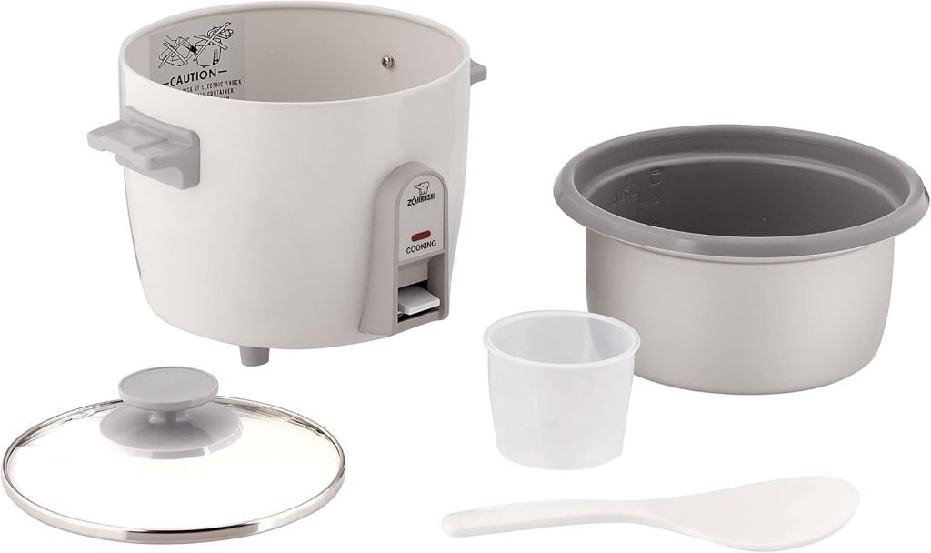 Compact Zojirushi rice cooker with open lid showing cooked rice