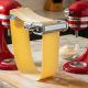 KitchenAid stand mixer with pasta roller attachment producing thin sheets of homemade lasagna dough