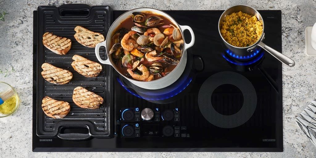 Built-in induction cooktop with pot boiling water on sleek countertop.