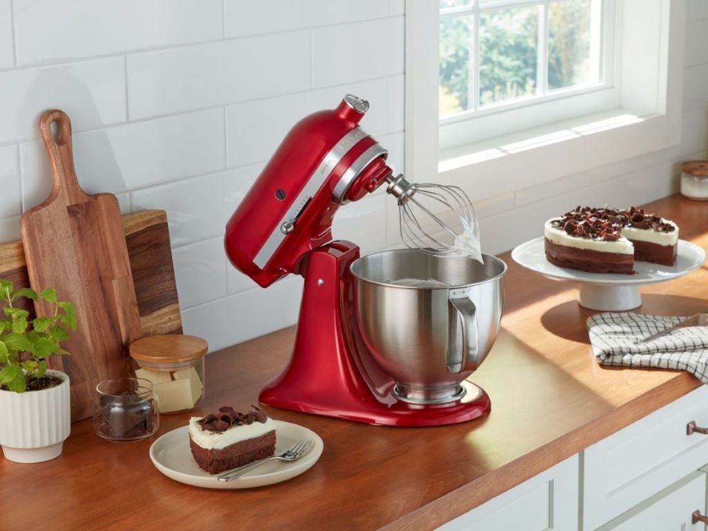 Baker using an electric mixer to prepare cake batter in a kitchen