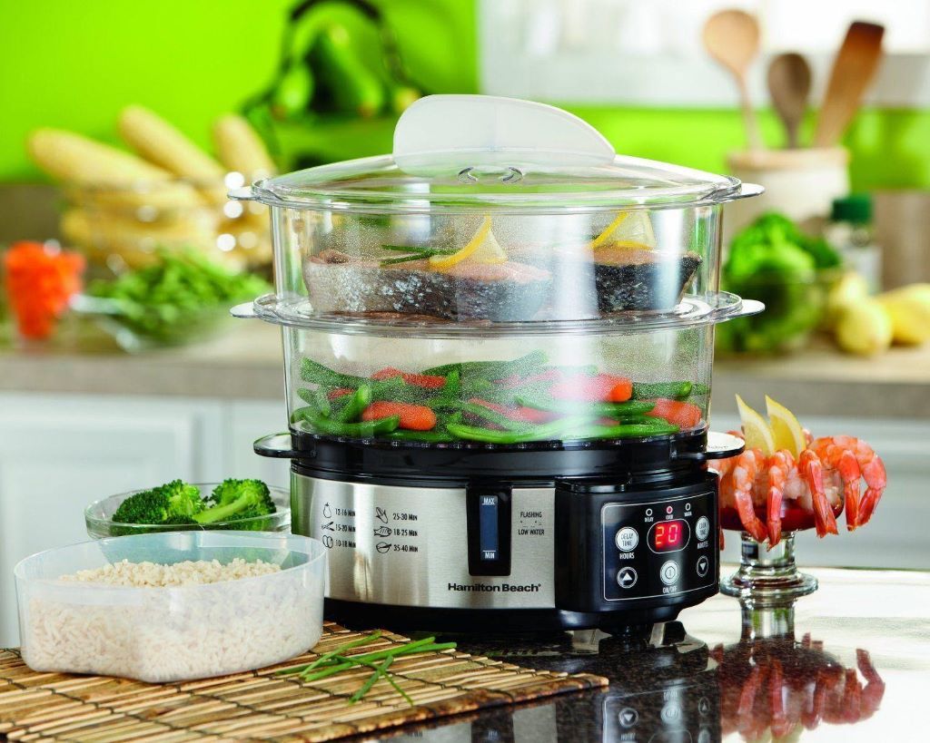 Close-up of layered electric steamer preparing nutritious steamed food like broccoli and chicken