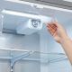Technician twisting replacement water filter into refrigerator ceiling dock